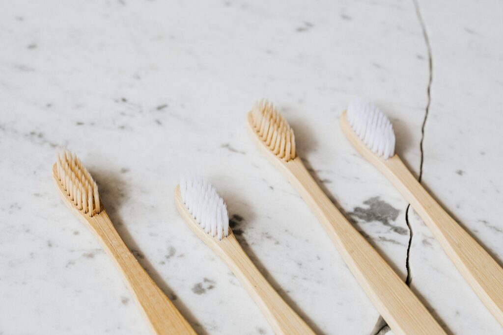 Bamboo toothbrushes on marble surface, representing sustainable dental care.