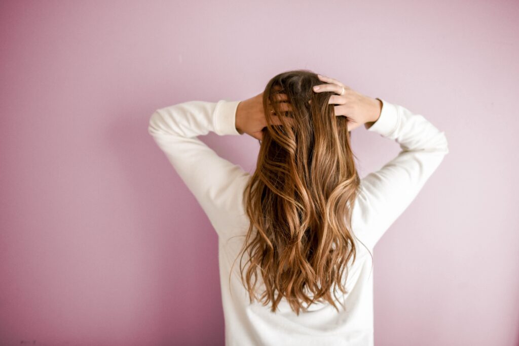 Woman holding her hair back, showcasing natural hair care without plastic products.