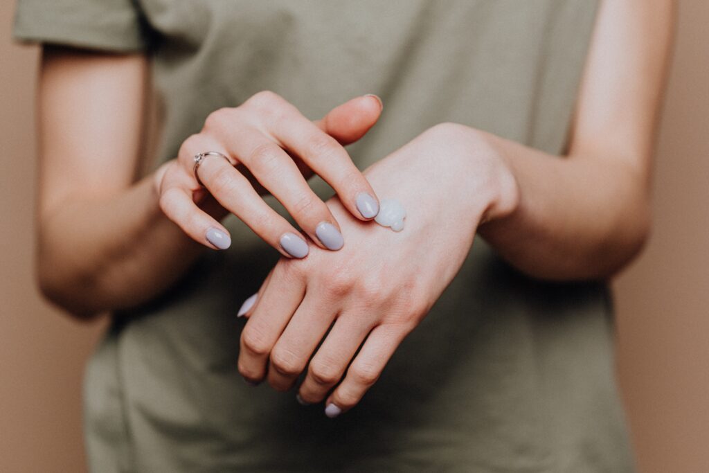 Applying lotion from a plastic-free container for sustainable skin care.