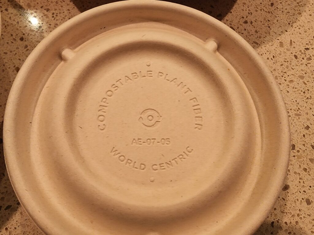 A close-up of a compostable to-go container made from plant fiber, as an alternative to plastic.